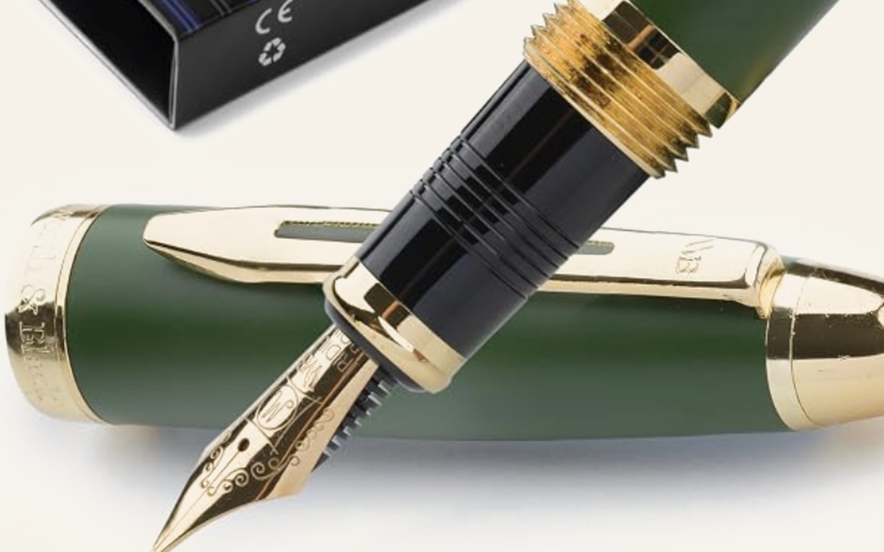 Una pluma estilográfica verde oscuro con plumín dorado, destapada y apoyada sobre su propio cuerpo.